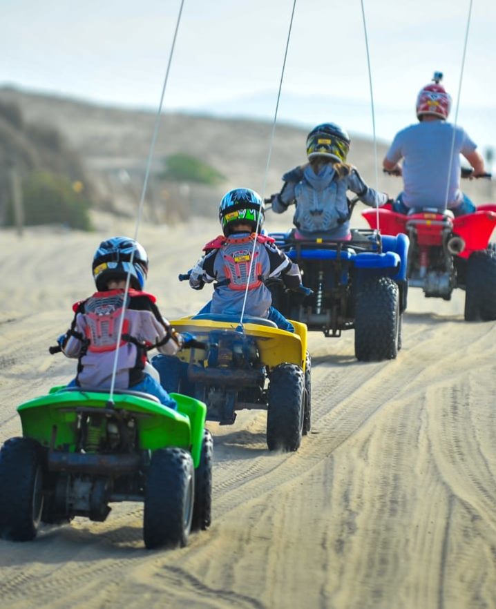 Family riding ATVs at Pismo Beach
