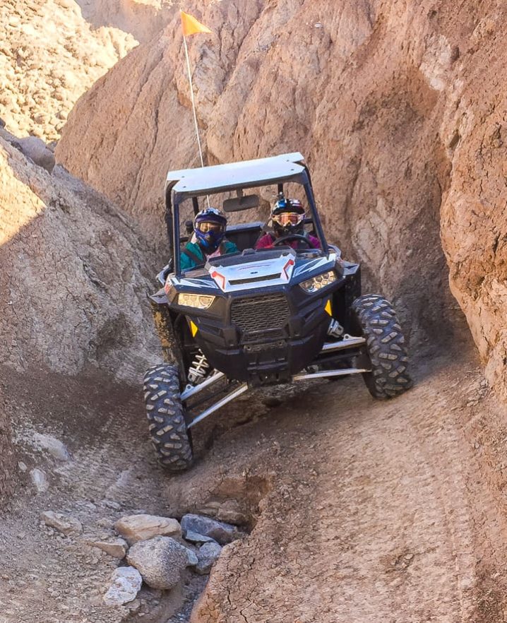 Two guests riding Polaris RZR 900-2 through rocky terrain in Palm Springs