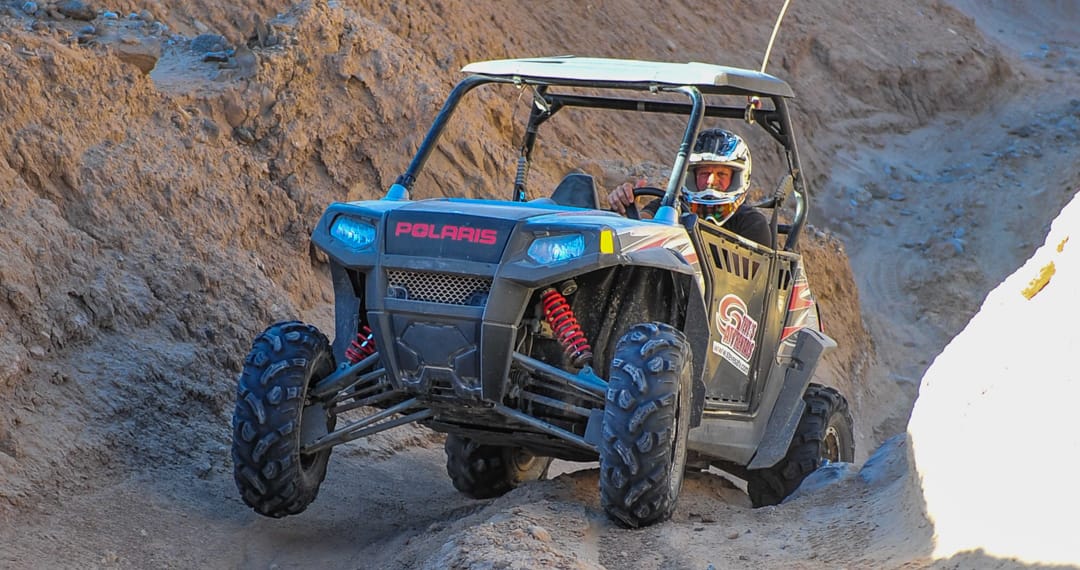 Guest riding on a Polaris RZR through rocky terrain at Palm Springs