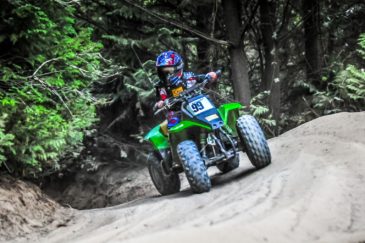 Child and guest sitting in an ATV giving the thumbs up