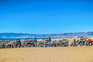 Steve ATV rental vehicles parked at Pismo Beach with guests standing nearby